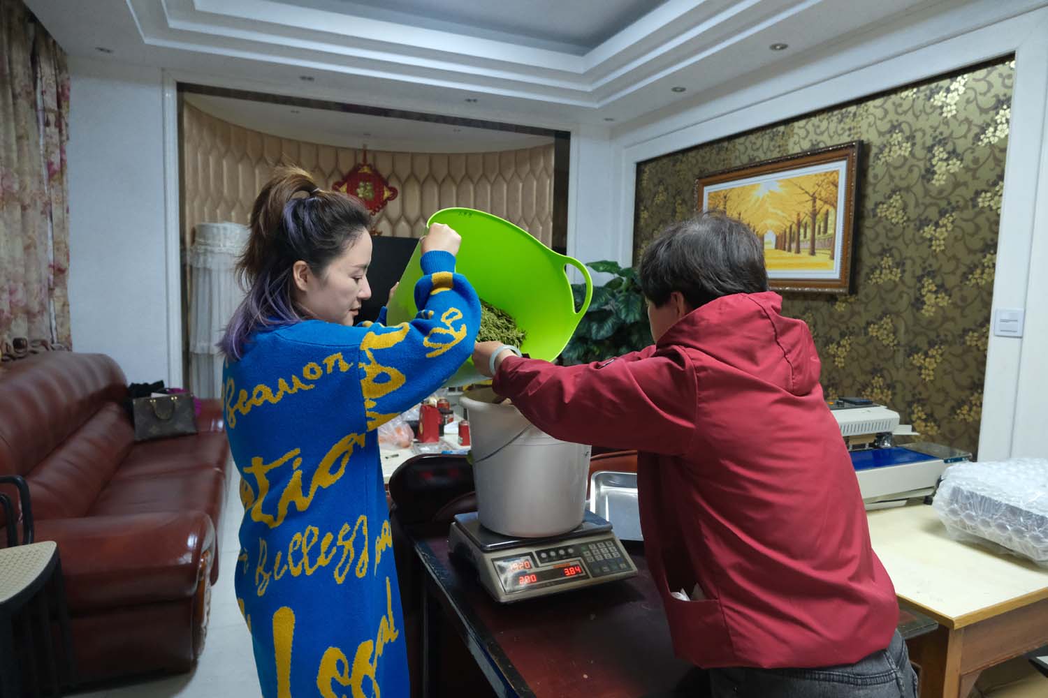 Zhu Xiaoqing and her mother, Yang Meihe, weigh dried tea leaves at their home in Meijiawu.